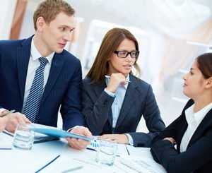 ejecutivos escuchando a una persona hablar