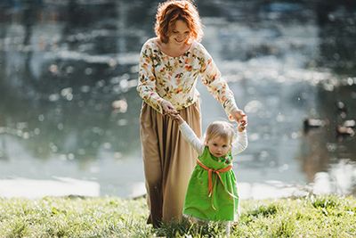 Madre con su hija caminando cerca del lago