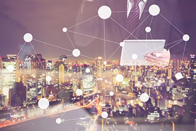 ciudad de noche de fondo hombre con una tablet en la mano