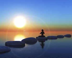 mujer en pose de yoga, sentada en un piedra plana sobre el mar, atardecer