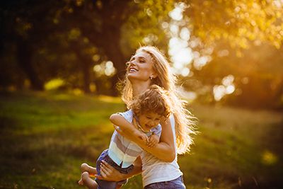 Joven madre con su hijo, divertidos en un parque