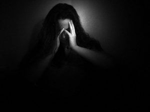 mujer tapándose la cara con las manos 